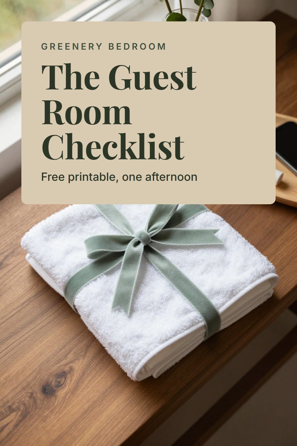 An overhead flat-lay of white towels tied with sage velvet ribbon beside a glass carafe and a small wooden tray of essentials