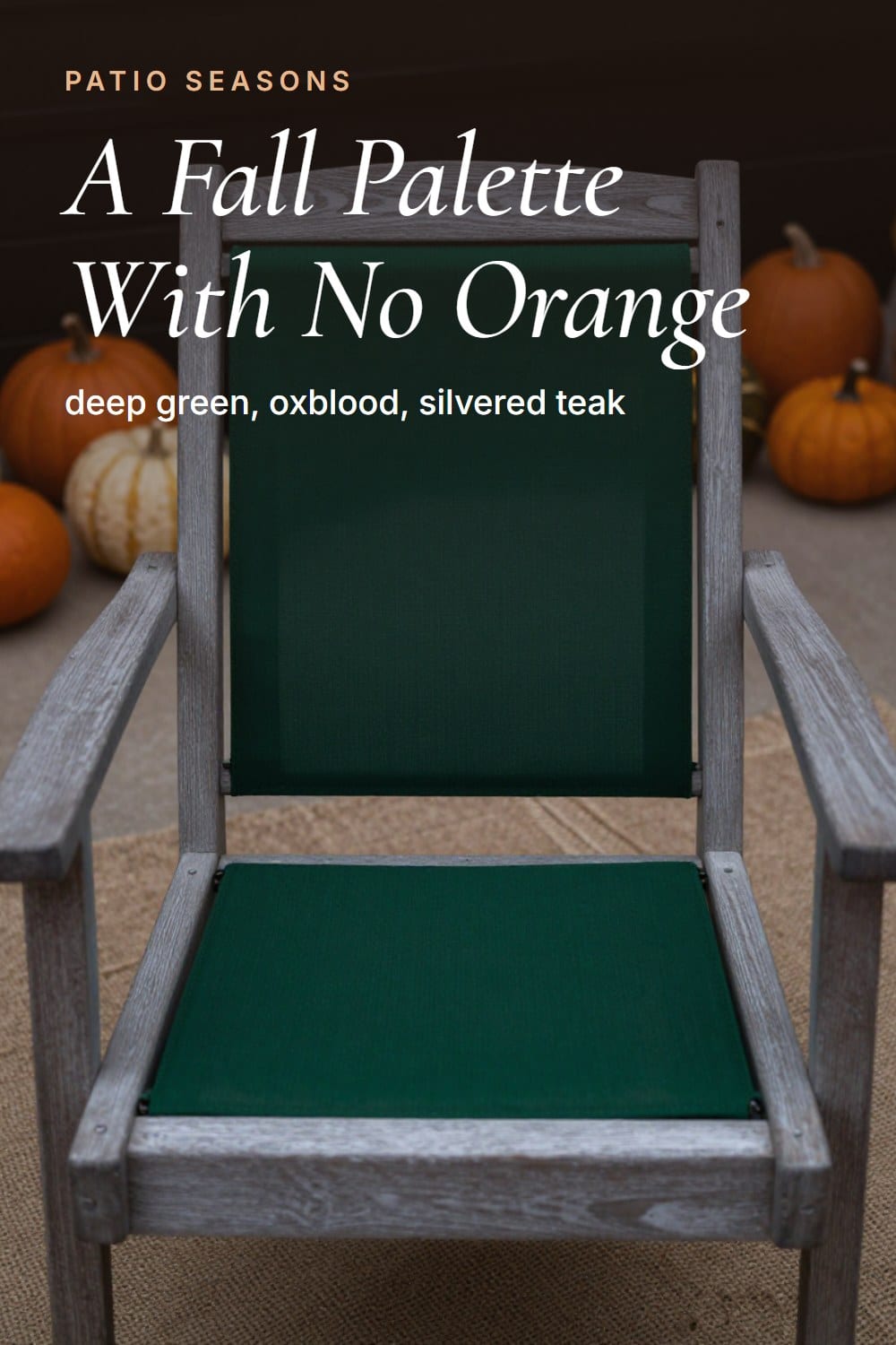 A seat-level view from a teak chair across a patio styled in deep green and oxblood with no orange anywhere