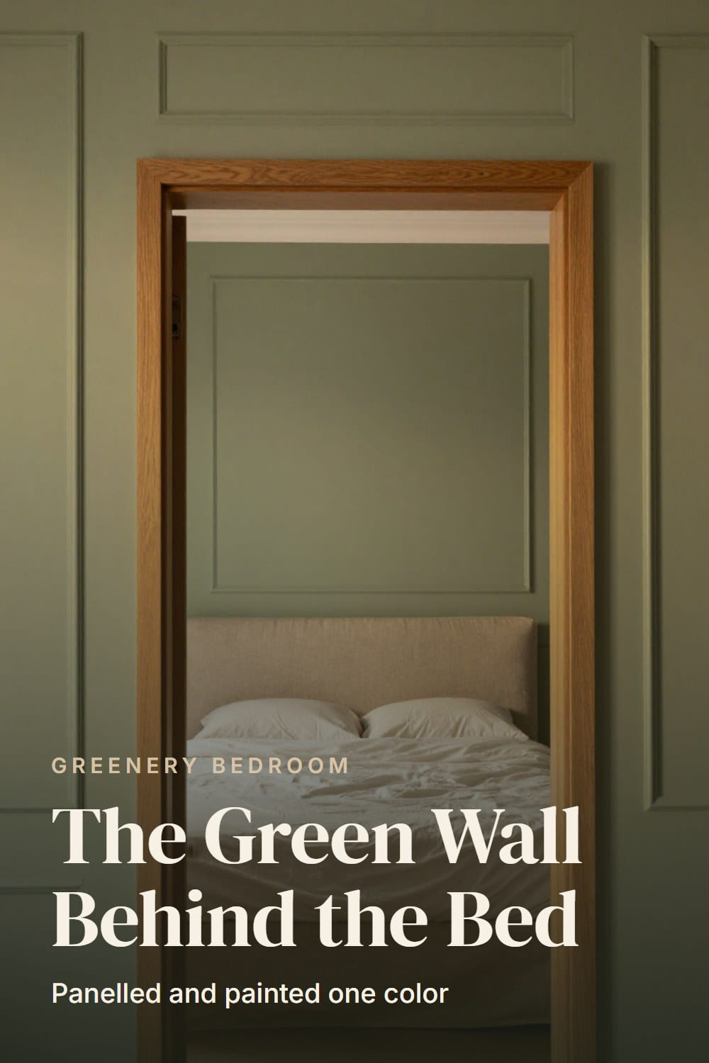 Doorway view of a bed centered against a green panelled wall made of tall picture-frame rectangles