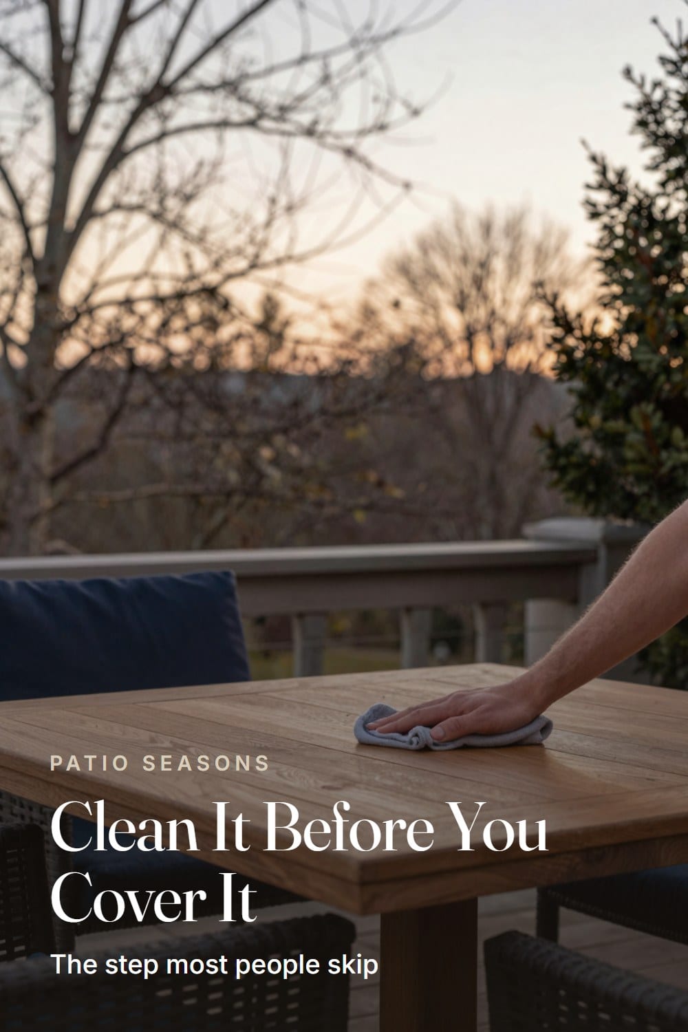 Hands-in-frame styling moment wiping down a teak patio table before winter