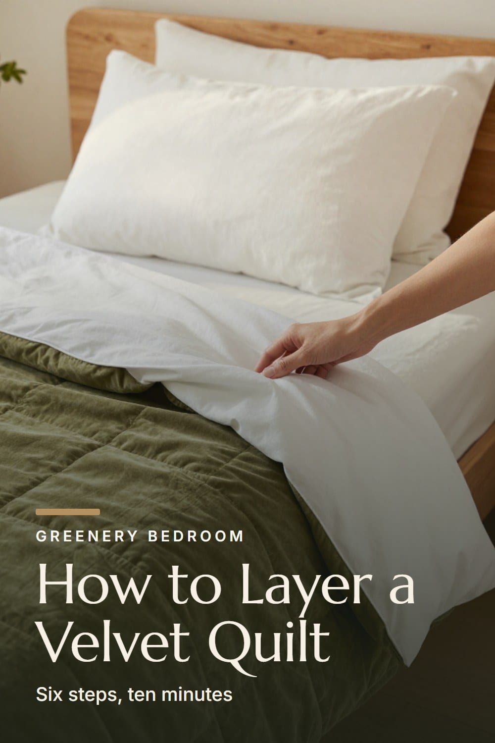 Hands folding the top edge of a white percale sheet back over an olive velvet quilt on a made bed