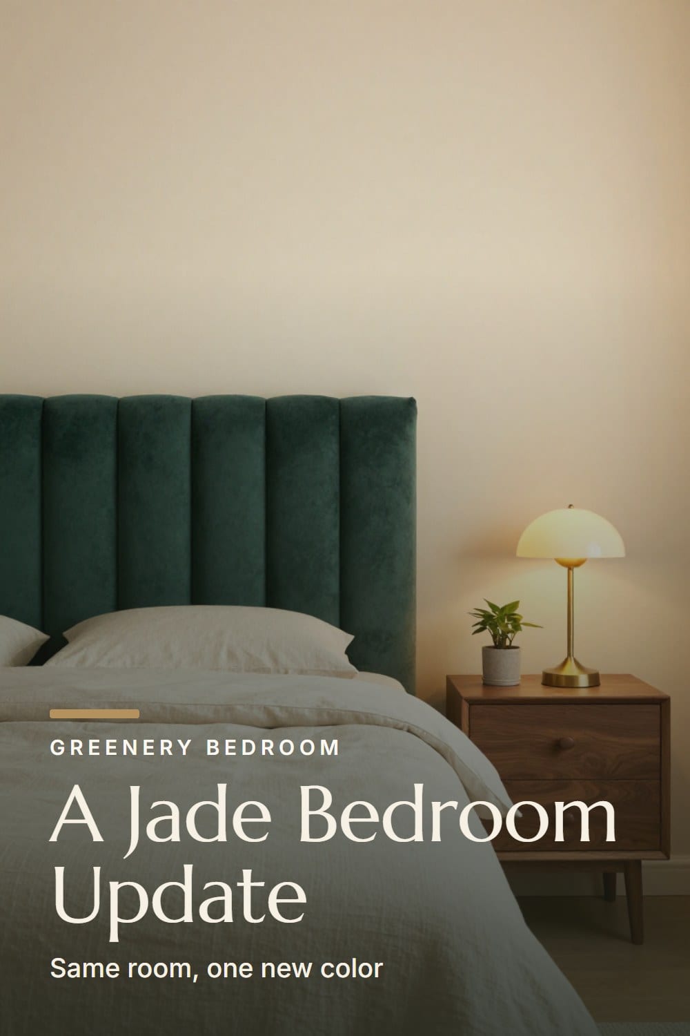 A slept-in bed with a jade velvet headboard against a warm cream wall, a walnut nightstand and a glowing brass lamp at golden hour