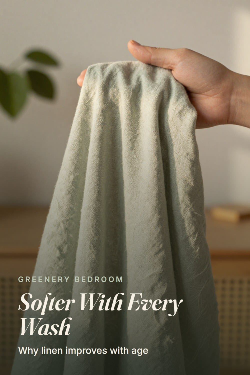 Macro of washed sage linen fabric draped over a hand showing the slubby weave in morning light