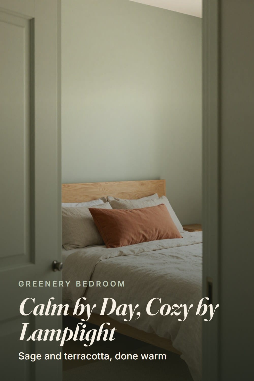 Doorway view of a warm sage and terracotta bedroom with an oak bed and a rust lumbar pillow in morning light